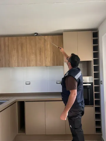 Inspector revisando muebles altos de cocina