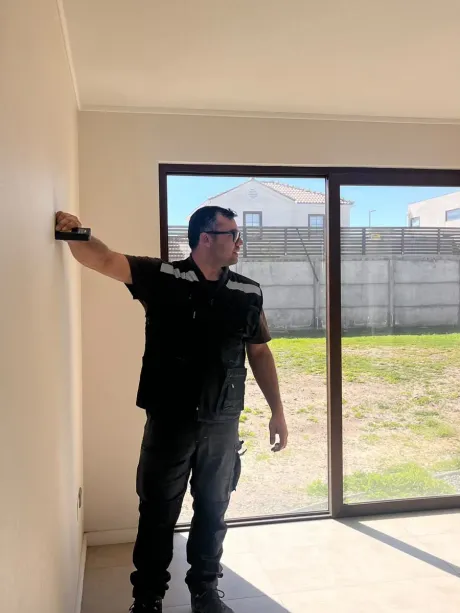 Inspector de SDS revisando muros y ventanas de un departamento nuevo