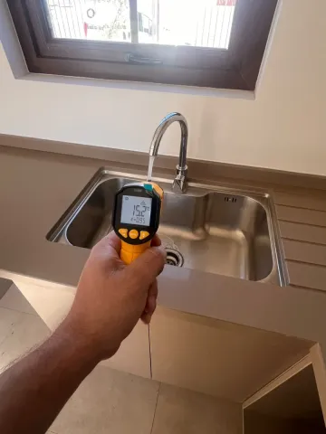 Termómetro infrarrojo midiendo el agua del lavaplatos